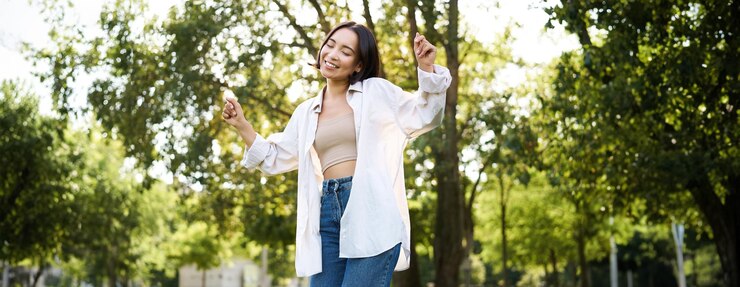 無料Photo 幸せな人々は、幸せと喜びを感じて公園で踊り、散歩を楽しむ屈託のないアジアの女の子
