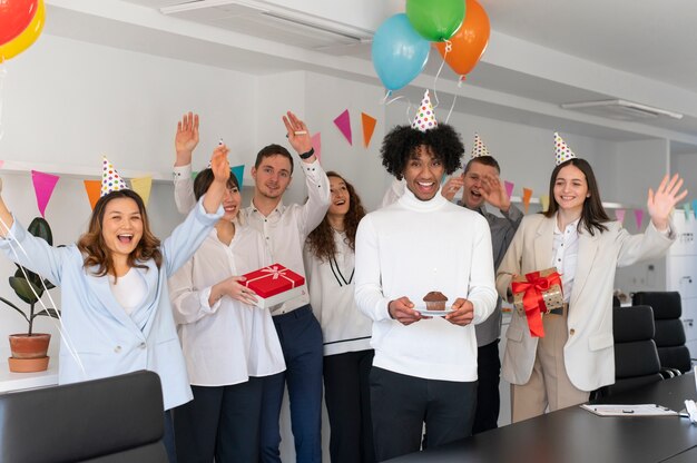 Happy people celebrating at work medium shot