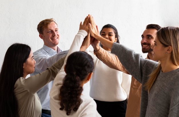 Happy people high-fiving each other at a group therapy session