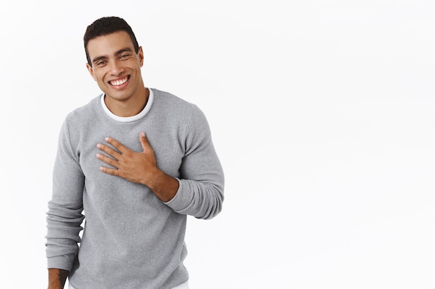 Free photo happy and pleased, flattered hispanic man thanking for praises