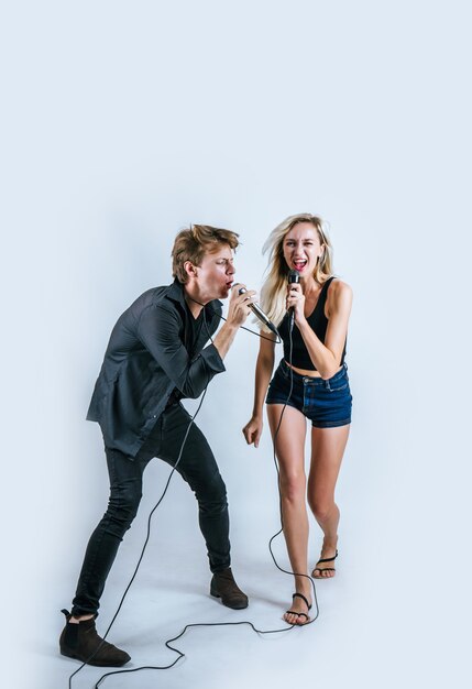 Happy portrait of Couple holding microphone and sing a song