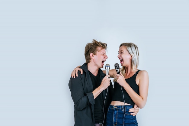 Happy portrait of Couple holding microphone and sing a song