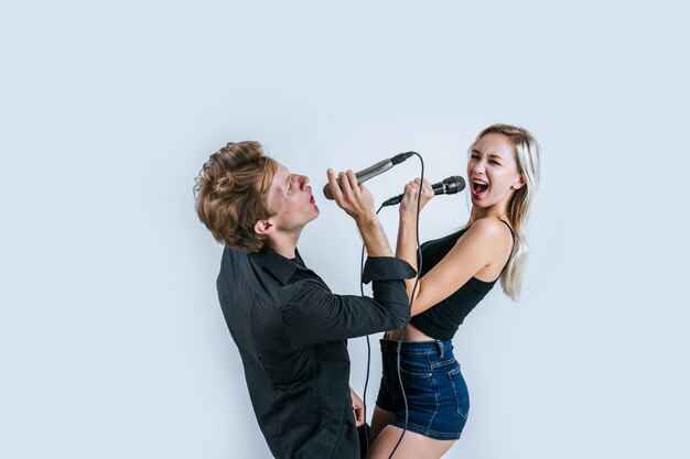 Счастливый портрет пары, держащей микрофон и поют песню