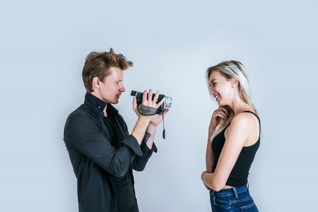 Счастливый портрет пары, держащей видеокамеру и запись клипа