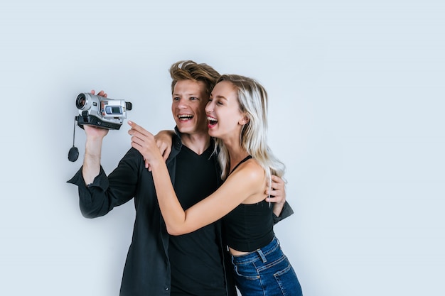 Счастливый портрет пары, держащей видеокамеру и запись клипа