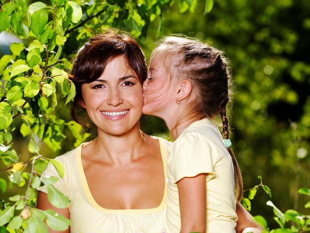 Happy portrait of the mother and little daughter outdoors