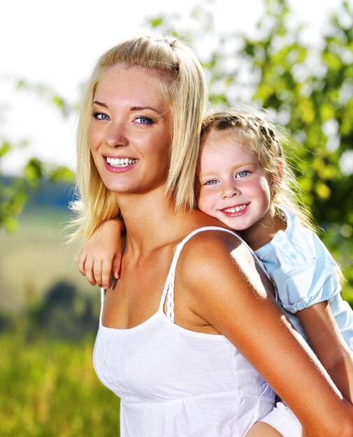 Счастливый портрет матери и маленькой дочери на открытом воздухе