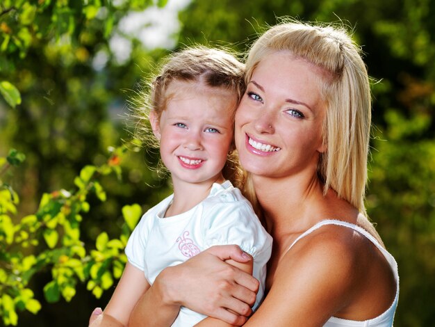 Happy portrait of the mother and little daughter outdoors