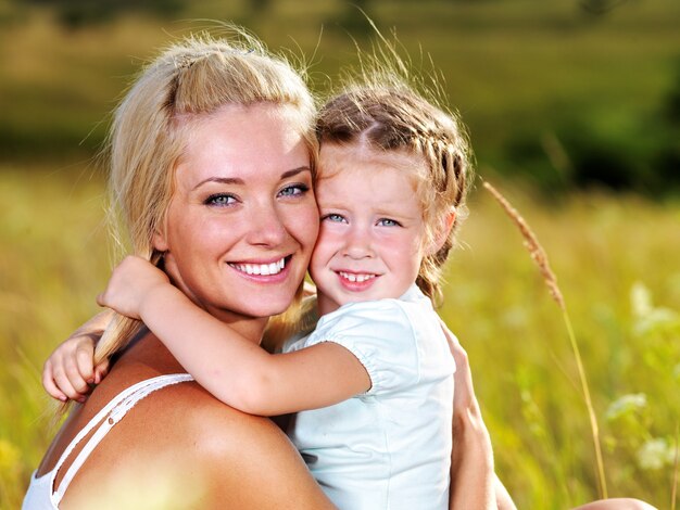 Happy portrait of the mother and little daughter outdoors