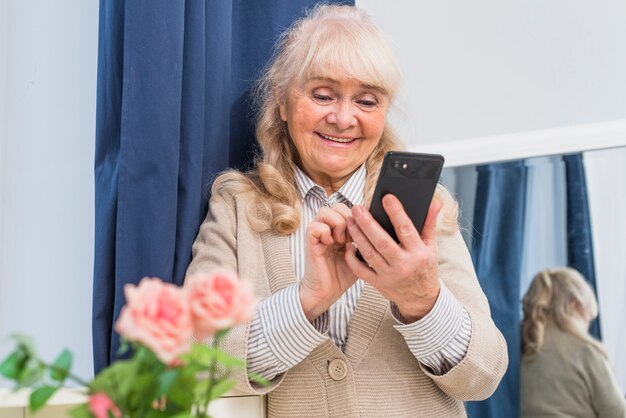 Happy portrait of a senior woman using mobile phone