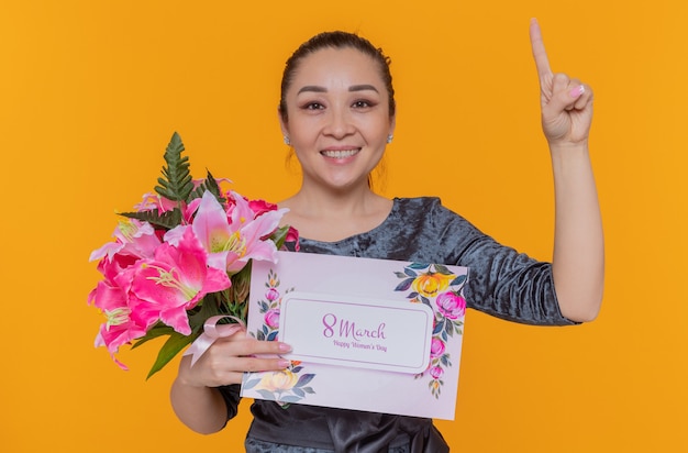 Happy and positive asian woman mother holding bouquet of flowers and greeting card celebrating international womens day march