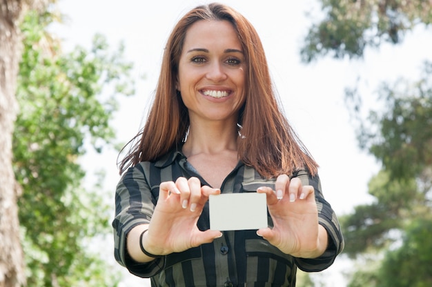 Happy positive female customer holding white badge