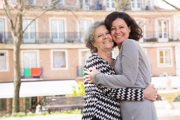 Happy positive mother and daughter standing for camera