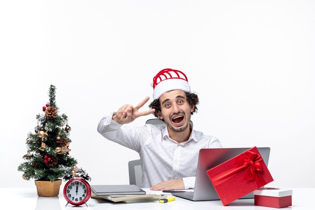 흰색 바탕에 사무실에서 두 보여주는 재미있는 산타 클로스 모자와 함께 행복 한 긍정적 인 젊은 사업가