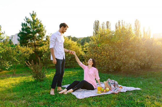 Happy pregnant couple in park on picnik