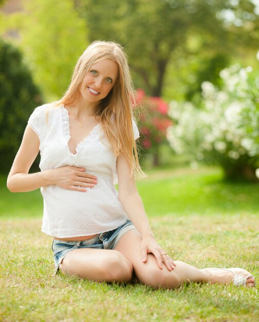 잔디에 행복 한 임신 여자