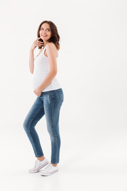 Happy pregnant woman standing isolated
