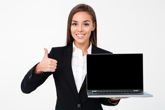 Happy pretty businesswoman showing display of laptop with thumbs up