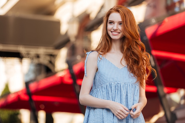 Happy pretty redhead girl with long hair posing