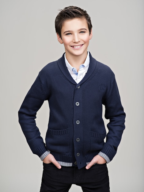 Happy pretty teenage boy posing at studio as a fashion model.