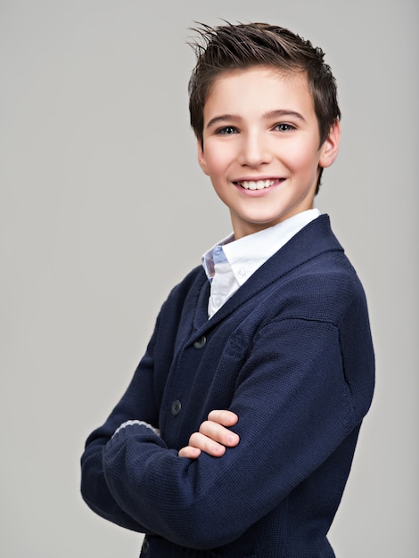 Happy pretty teenage boy posing at studio as a fashion model.