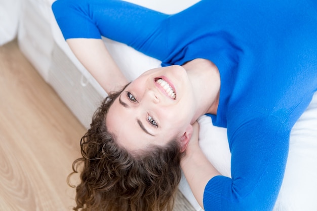 Happy Pretty Woman Resting on Bed Upside Down