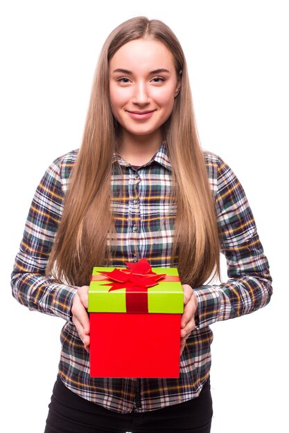 Happy pretty young woman holding gift box over white wall