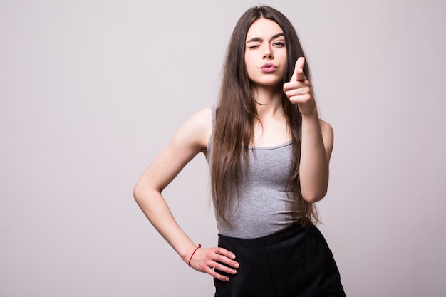 Happy pretty young woman standing and pointing