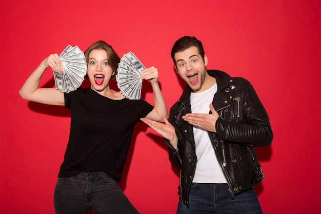 Free photo happy punk woman showing the money while punk man posing