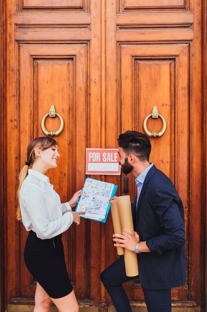 Happy real estate agent showing plans 