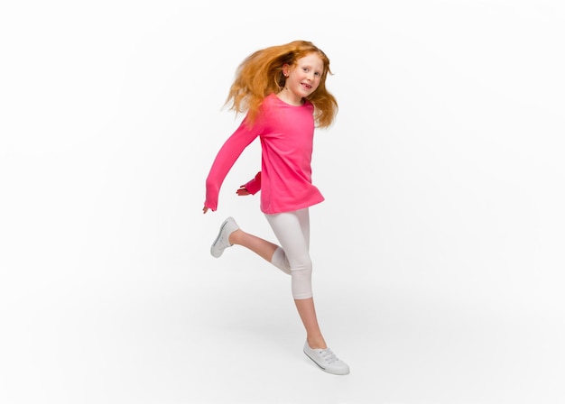 Happy redhair girl isolated on white studio background Looks happy cheerful sincere Copyspace Childhood education emotions concept