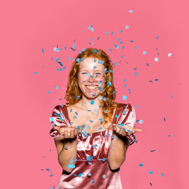 Happy redhead girl throwing confetti