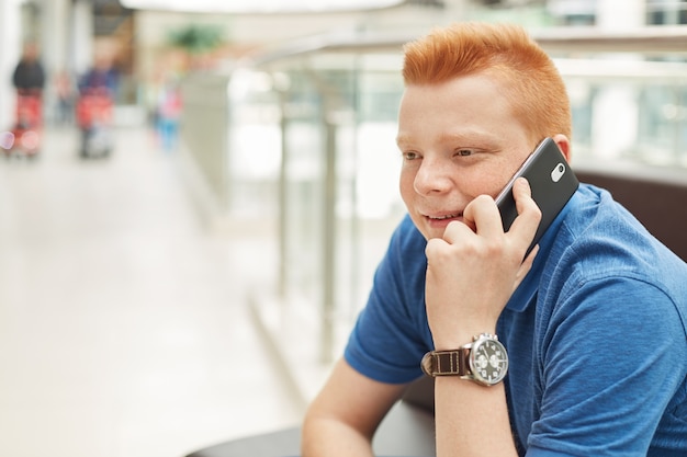 A happy redhead man with freckles wearing casual blue