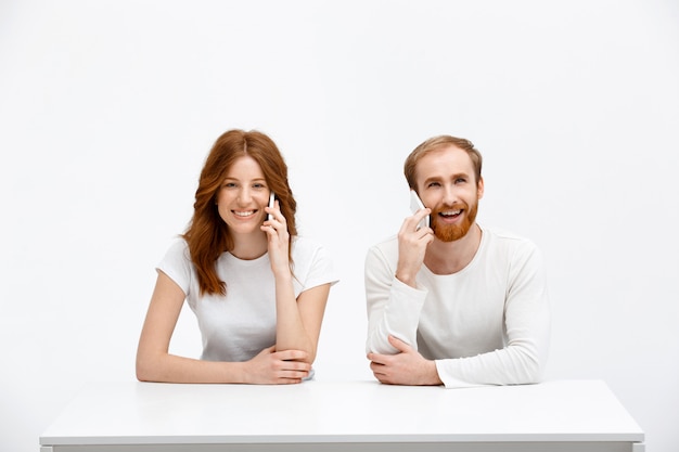 Happy redhead man and woman talk mobile phone