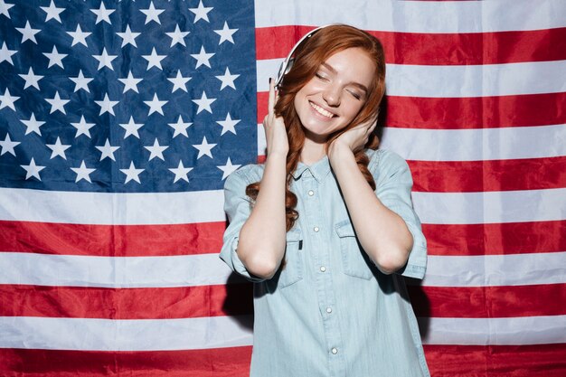 Happy redhead young lady listening music