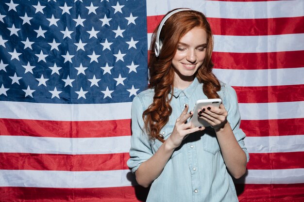 Happy redhead young lady listening music