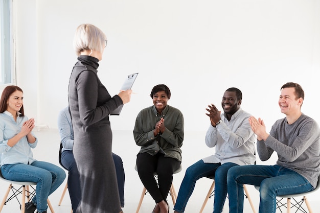 Happy rehab patients applauding doctor