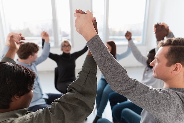 Foto gratuita felice riabilitazione pazienti alzando le mani