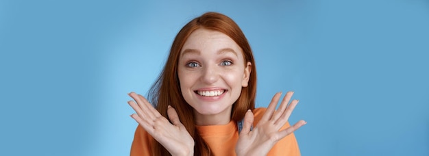 Free photo happy rejoicing emotional young smiling redhead girl blue eyes getting exciting news grinning