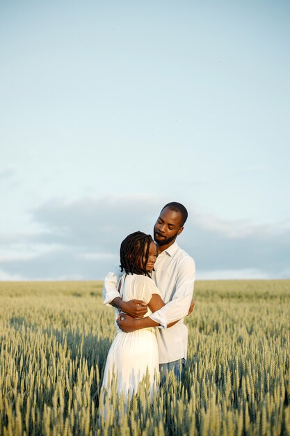 Happy romantic couple hugging in a summer field