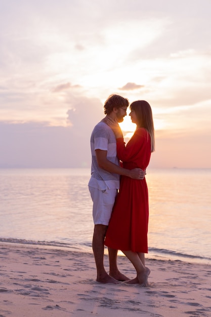 Happy romantic couple on tropical beach at sunset.