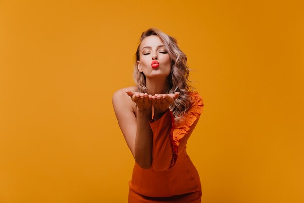 Happy romantic woman in orange dress expressing love