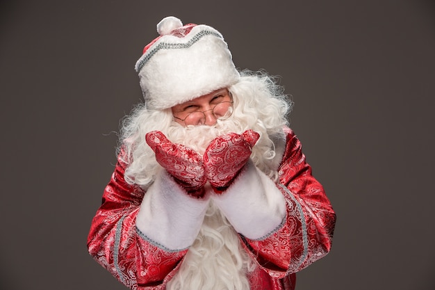 Foto gratuita babbo natale felice in occhiali che guarda l'obbiettivo su sfondo scuro