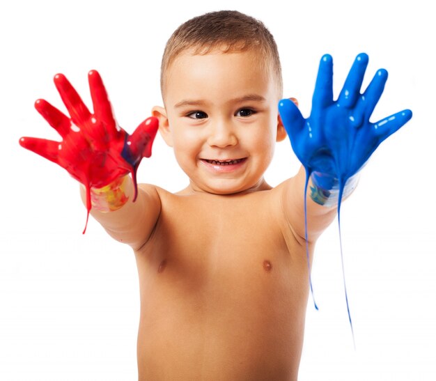 Happy schoolboy showing his hands full of paint