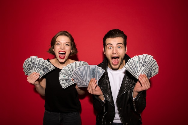 Happy screaming punk couple posing with money and rejoice