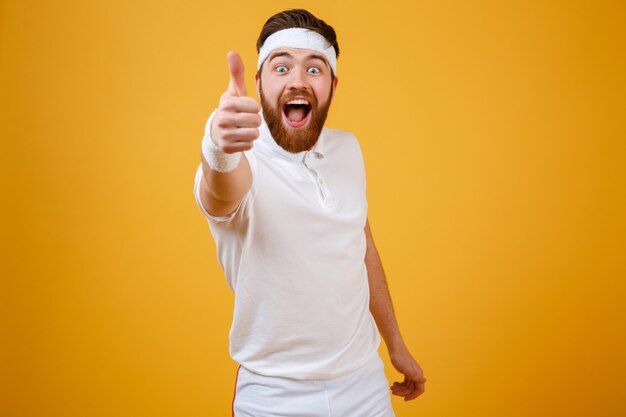 Happy screaming sportsman showing thumb up at camera