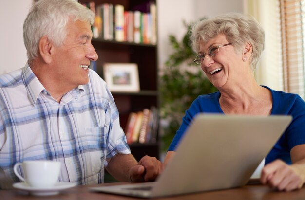 Happy senior couple using their laptop
