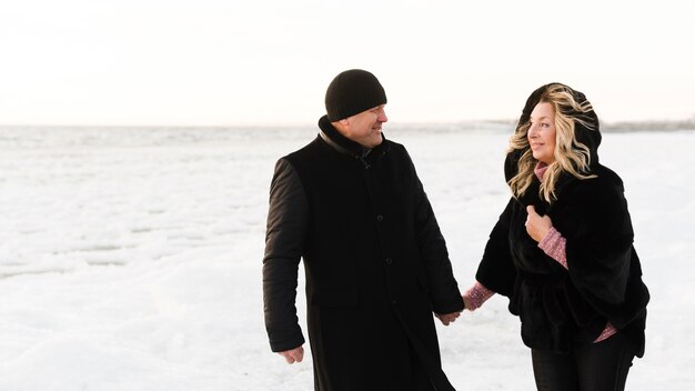 Happy senior couple walking on beach