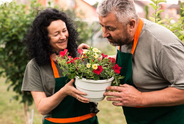 Happy senior couple with a flower pot