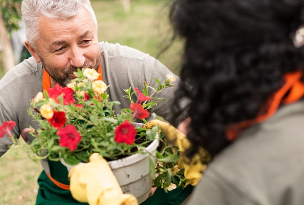 Free photo happy senior couple with flowers